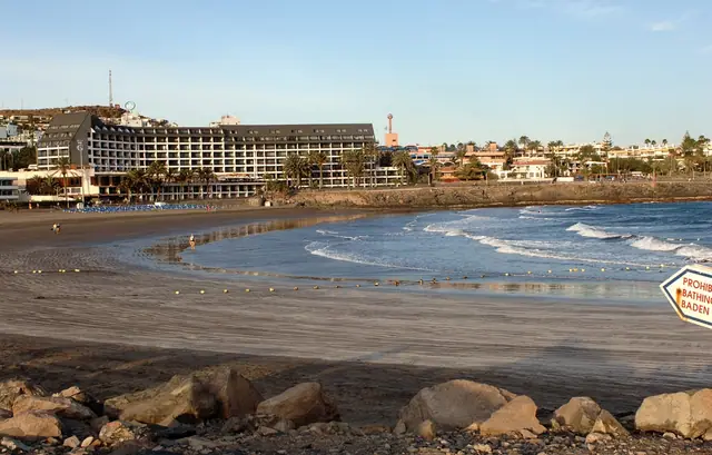 Playa de las Burras beach in Gran Canaria, featuring a sandy shoreline with moderate water conditions, certified with Blue Flag status for environmental quality