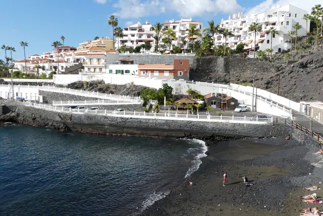 Playa Chica beach in Tenerife, featuring a sandy shoreline with calm water conditions