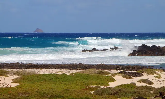 White Cove Beach in La Graciosa, featuring a sandy shoreline with moderate water conditions