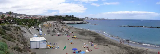 Playa El Duque beach in Tenerife, featuring a sandy shoreline with calm water conditions