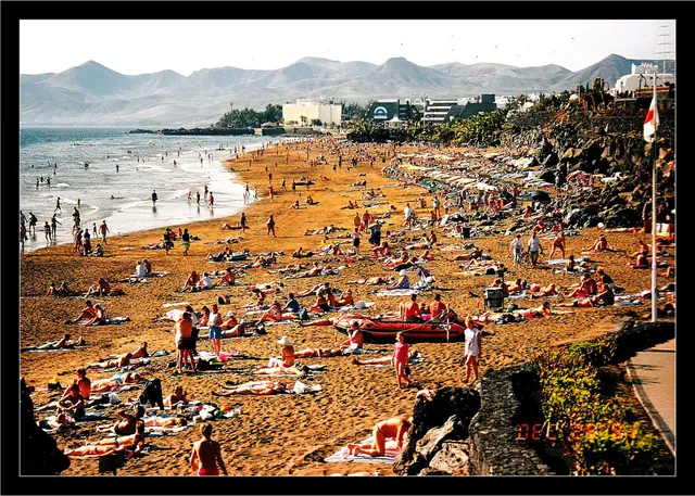 Playa Grande beach in Lanzarote, featuring a sandy shoreline with moderate water conditions