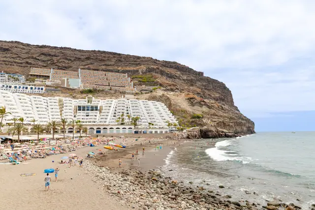 Playa Taurito beach in Gran Canaria, featuring a sandy shoreline with calm water conditions