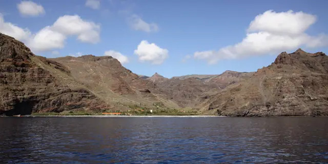Playa del Cabrito beach in La Gomera, featuring a pebbly shoreline with calm water conditions