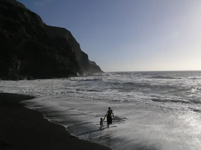 Playa de Alojera beach in La Gomera, featuring a pebbly shoreline with wavy water conditions