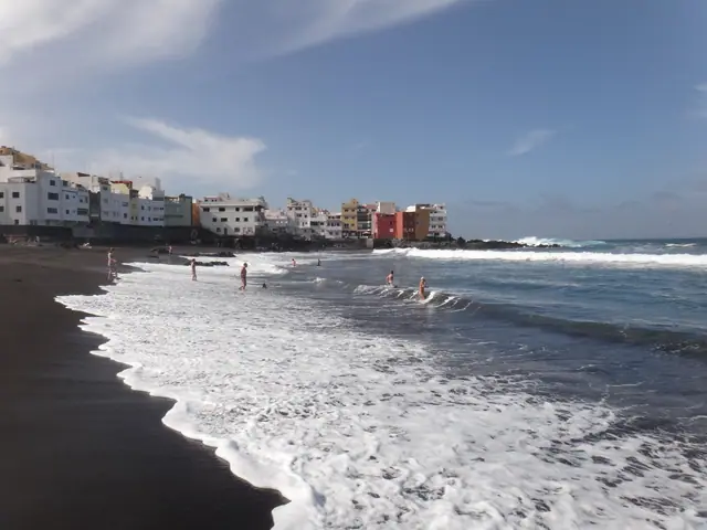 Playa Punta Brava beach in Tenerife, featuring a sandy shoreline with wavy water conditions