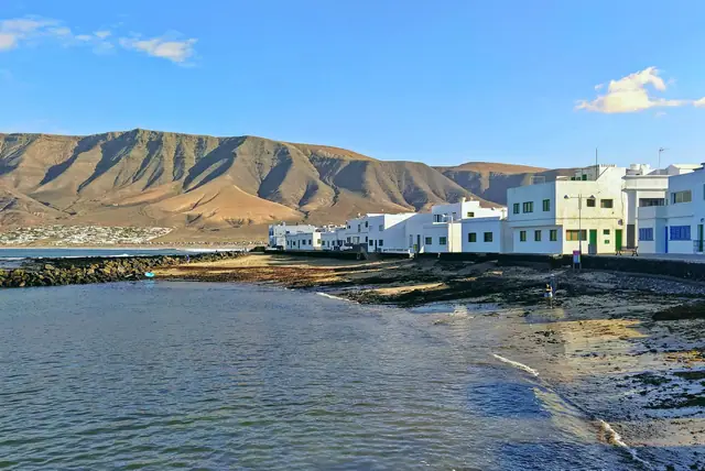 La Charquita beach in Lanzarote, featuring a sandy shoreline with calm water conditions