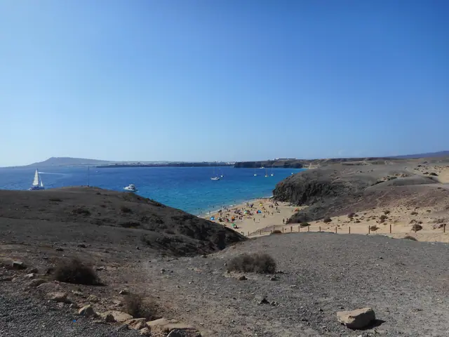 Playa de la Cera beach in Lanzarote, featuring a sandy shoreline with moderate water conditions