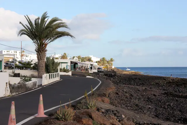 Playa Quemada beach in Lanzarote, featuring a sandy shoreline with calm water conditions