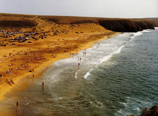 Playa Caleta del Congrio beach in Lanzarote, featuring a sandy shoreline with moderate water conditions