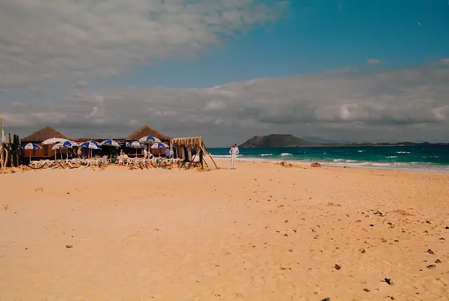 Playa del Pozo beach in Fuerteventura, featuring a sandy shoreline with wavy water conditions