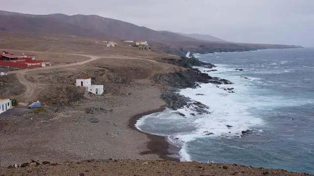 Playa del Valle beach in Fuerteventura, featuring a pebbly shoreline with moderate water conditions