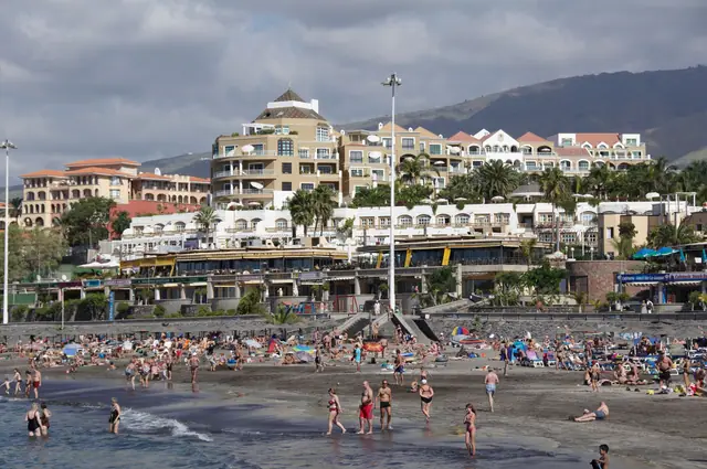 Playa de Fañabe beach in Tenerife, featuring a sandy shoreline with calm water conditions