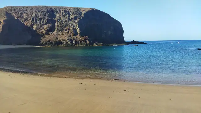 Papagayo Beach in Lanzarote, featuring a sandy shoreline with calm water conditions