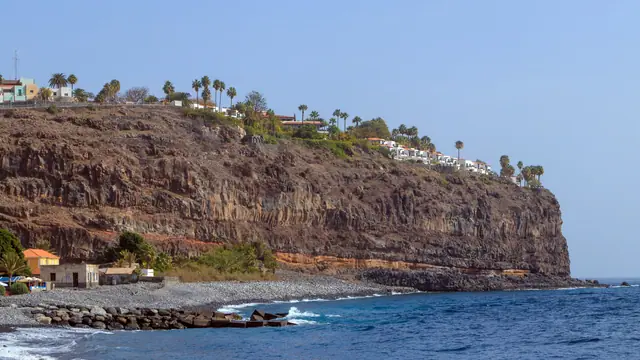Playa de Santiago beach in La Gomera, featuring a pebbly shoreline with moderate water conditions, certified with Blue Flag status for environmental quality