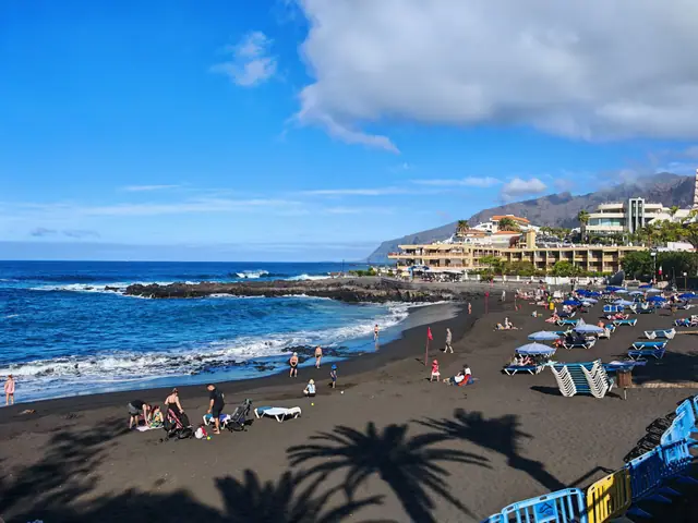 Neptune Beach in Tenerife, featuring a sandy shoreline with calm water conditions