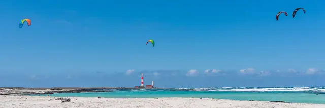 Caleta del Marrajo beach in Fuerteventura, featuring a sandy shoreline with moderate water conditions