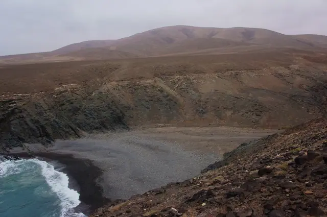 Playa de los Mozos beach in Fuerteventura, featuring a sandy shoreline with moderate water conditions