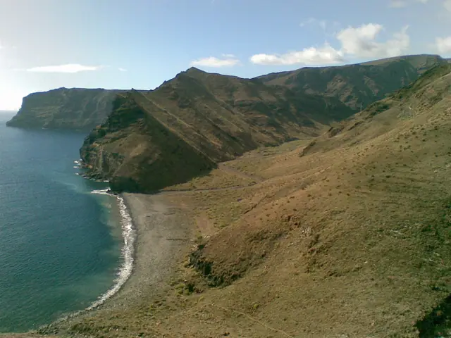 Playa de la Guancha beach in La Gomera, featuring a pebbly shoreline with wavy water conditions