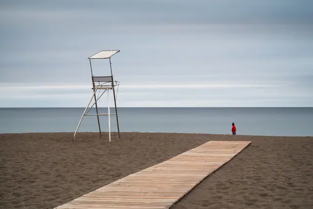 Playa de Melenara beach in Gran Canaria, featuring a sandy shoreline with moderate water conditions