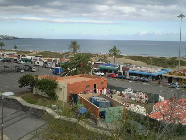 Playa de Cochino beach in Gran Canaria, featuring a sandy shoreline with calm water conditions