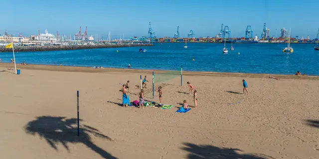 Playa de Las Alcaravaneras beach in Gran Canaria, featuring a sandy shoreline with calm water conditions