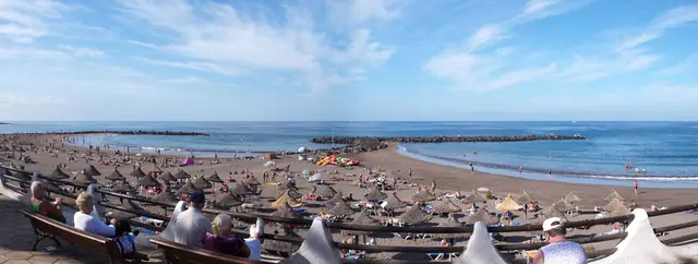 Playa de Troya beach in Tenerife, featuring a sandy shoreline with calm water conditions