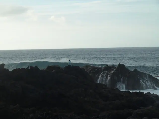 Playa de los Barqueros beach in Tenerife, featuring a pebbly shoreline with wavy water conditions