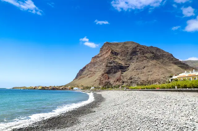 Playa de La Puntilla beach in La Gomera, featuring a sandy shoreline with calm water conditions