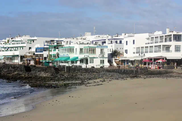 Playa del Pueblo beach in Lanzarote, featuring a sandy shoreline with calm water conditions