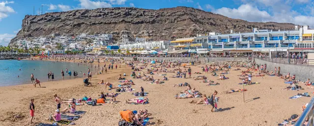 Playa de Mogán beach in Gran Canaria, featuring a sandy shoreline with calm water conditions