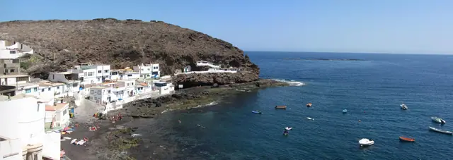 Playa de Agua Dulce beach in Gran Canaria, featuring a sandy shoreline with calm water conditions
