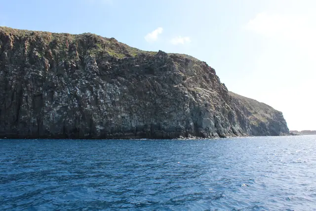 Playa del Callao beach in Tenerife, featuring a pebbly shoreline with moderate water conditions