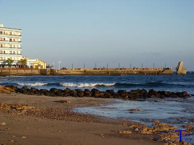 Playa de las Kañadas beach in Gran Canaria, featuring a pebbly shoreline with moderate water conditions