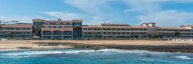 Playa las Agujas beach in Fuerteventura, featuring a sandy shoreline with wavy water conditions