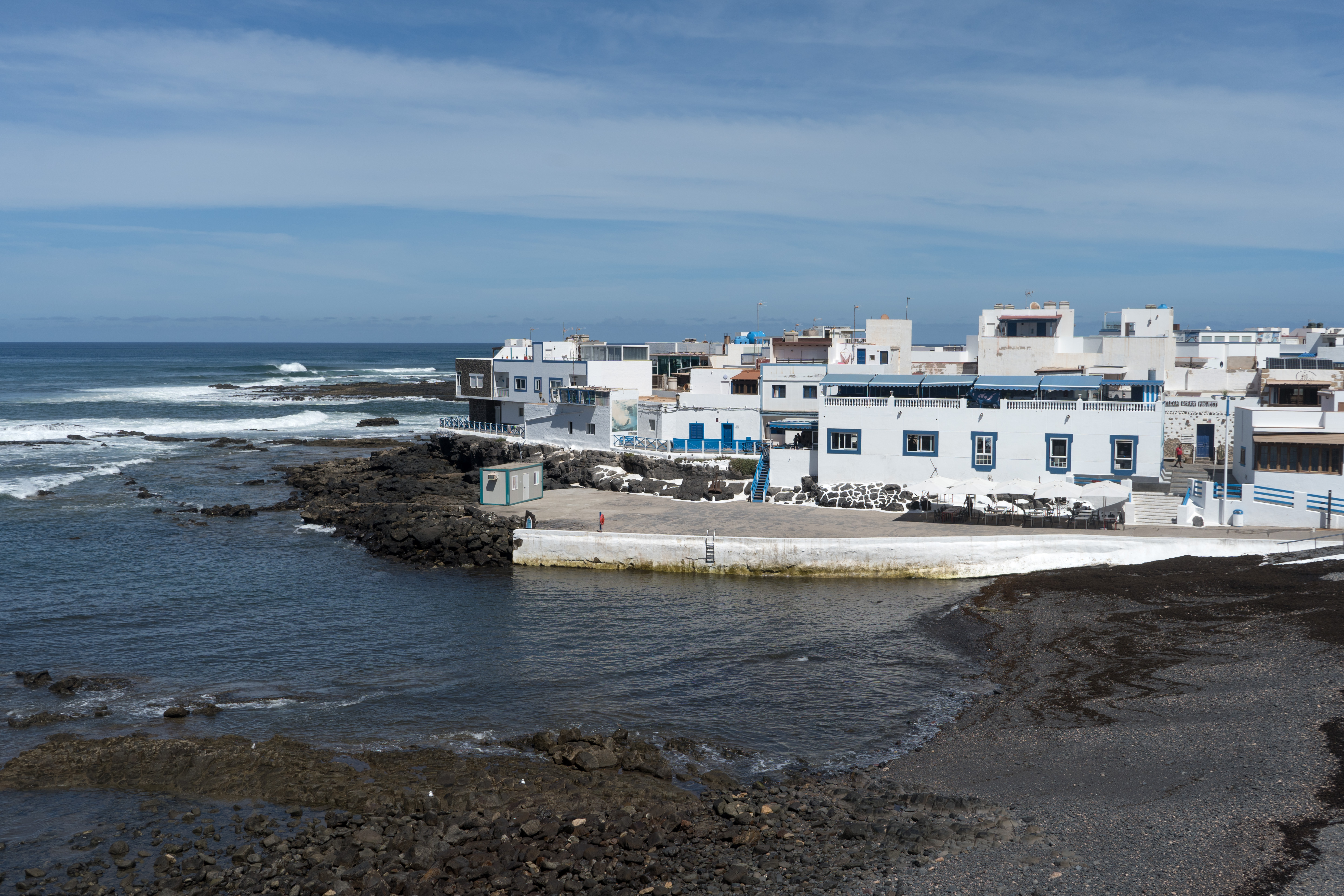 Caleta del Cotillo beach in Fuerteventura, featuring a pebbly shoreline with surfable water conditions