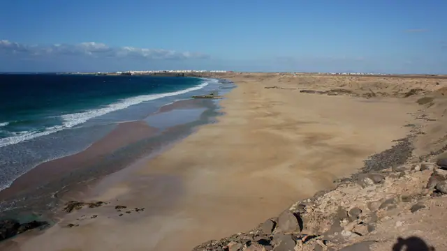Playa Mallorquines beach in Fuerteventura, featuring a sandy shoreline with moderate water conditions