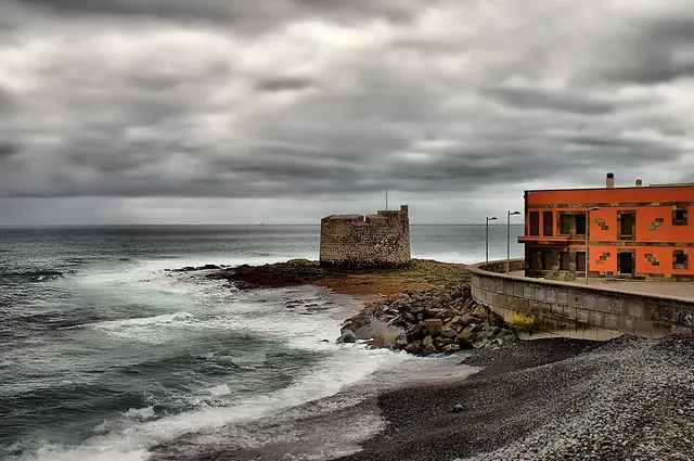 La Caleta beach in Gran Canaria, featuring a pebbly shoreline with moderate water conditions