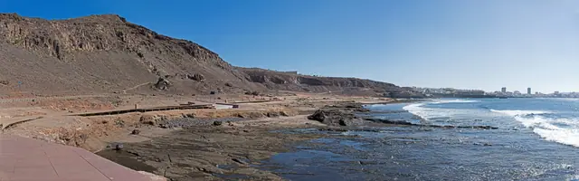 Playa del Confital beach in Gran Canaria, featuring a pebbly shoreline with surfable water conditions