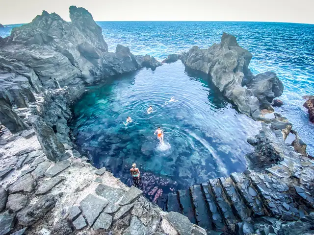 Playa de los Roques beach in Tenerife, featuring a pebbly shoreline with moderate water conditions