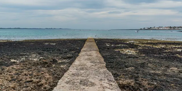 Corralejo Viejo (Waikiki Beach) beach in Fuerteventura, featuring a sandy shoreline with calm water conditions, certified with Blue Flag status for environmental quality