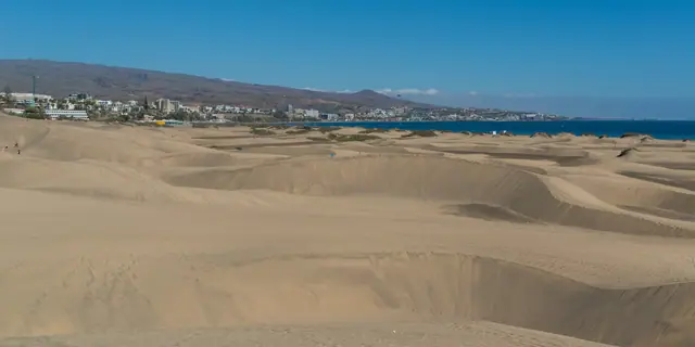 Playa del Inglés beach in Gran Canaria, featuring a sandy shoreline with calm water conditions