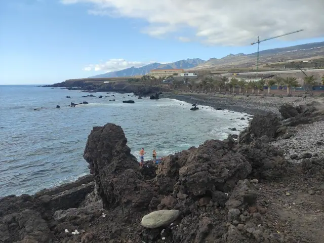 Playa de Fonsalía beach in Tenerife, featuring a pebbly shoreline with moderate water conditions