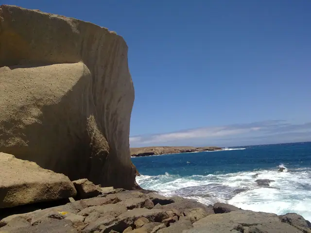 Playa Callao Hondo beach in Tenerife, featuring a pebbly shoreline with moderate water conditions