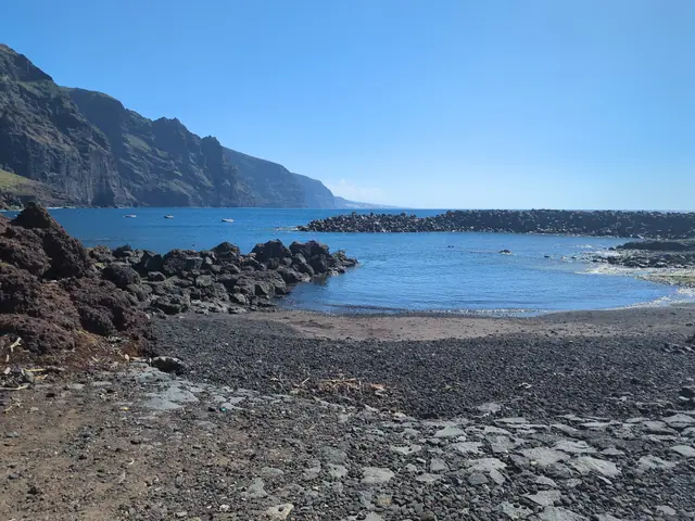 Playa de la Ballenita beach in Tenerife, featuring a pebbly shoreline with moderate water conditions